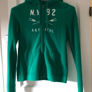 Hoodie - Skogsgrön hoodie i strl S från Abercrombie & Fitch. Den är i mycket fint skick, men har ett pyttelitet hål i ena ärmen som lätt fixas med ett par stygn. (Därför säljer jag den till ett lite billigare pris)