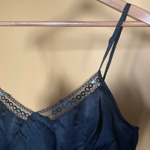 Sött linne - Jättefint svart linne i sidenmaterial med spets och paljett-detaljer. Fin festtopp som är nästintill oanvänd! Det står strl M men inte så mycket plats för brösten, så skulle säga en blandning mellan S o M. 🌼