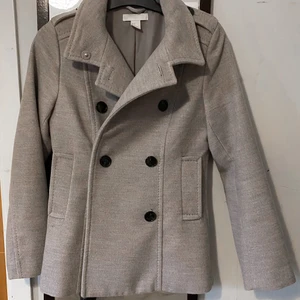 Kappa, H&M - Grå kortare kappa från H&M. Liten i storleken. Två fickor. Stängs med knappar. 