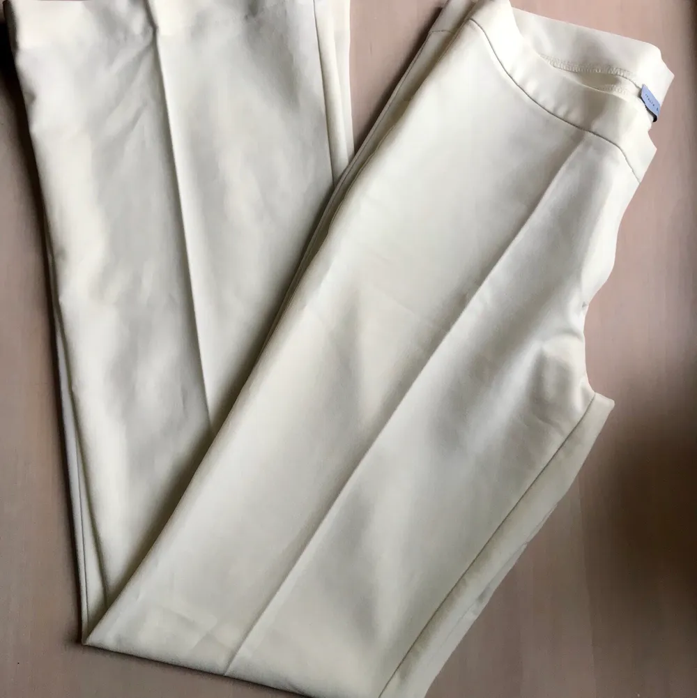 Låga gräddvita kostymbyxor med utsvängda byxben. Från ett märke som heter italia N.I.C.E. St L men liten i storleken. . Jeans & Byxor.