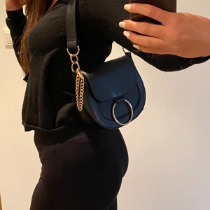 Svart handväska - Svart handväska från okänt märke med gulddetaljer. I mycket bra skick bara använd några gånger. 