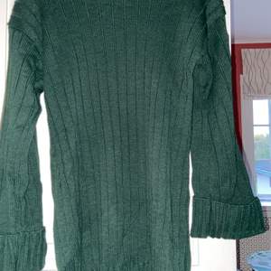 En grön stickad klänning men som man också kan använda som en lång tröja. Den är halvt polo och uppvikta armar. Skriv för fler bilder<33