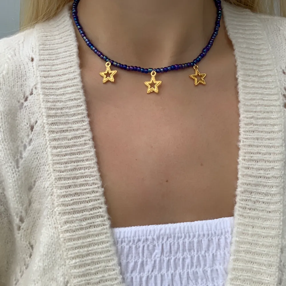 Blått pärlhalsband med guldiga stjärnor🤯🤩⭐️ halsbandet försluts med lås och tråden är elastisk . Accessoarer.