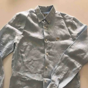  - Ljusblå linneskjorta i slimfit. Använd endast en gång och är i nyskick.