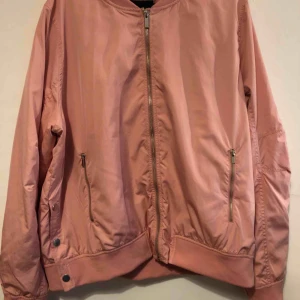  - En rosa bomberjacka från joy men är märker loul. Den är storlek L men passar någon med M om man vill ha den mer oversized den är tunn men fin!