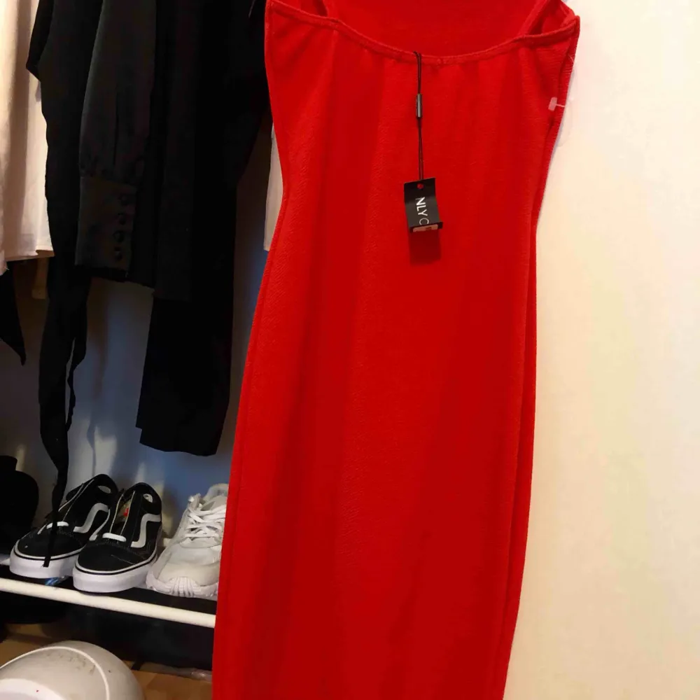 Oanvänd röd tight klänning. Klänningar.