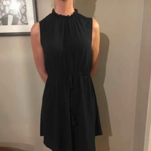  - Mörkblå klänning i skirt material med en fin knytning i midjan