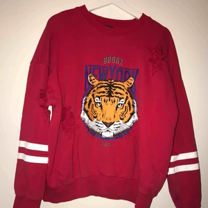  - En röd tiger tröja med slitningar från Gina tricot. Väldigt stor i storlek så funkar som XL också. Knappt använt pg.a storleken är för stor men annars super fin och hel tröja! 