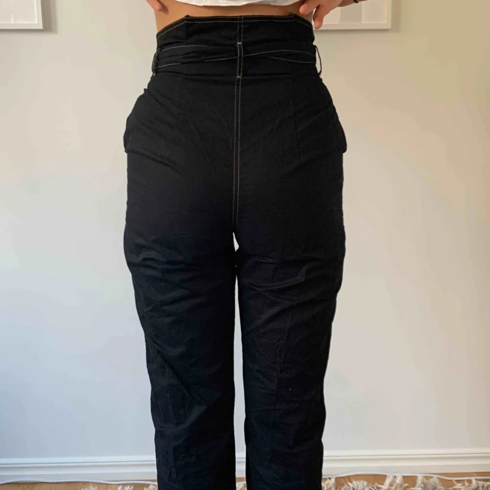 Ett par classy svarta byxor med beiga sömmar och cool midja! Från Carin Wester. Bra att veta: jag är 171 och de är sådär ^ långa på mig. I riktigt bra skick!😚. Jeans & Byxor.