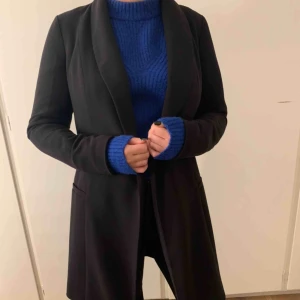  - Supersnygg svart kappa i rak modell från märket Stockh LM, har knyte i midjan som går att ta av. Endast använd ett fåtal gånger. Köparen står för frakten🥰