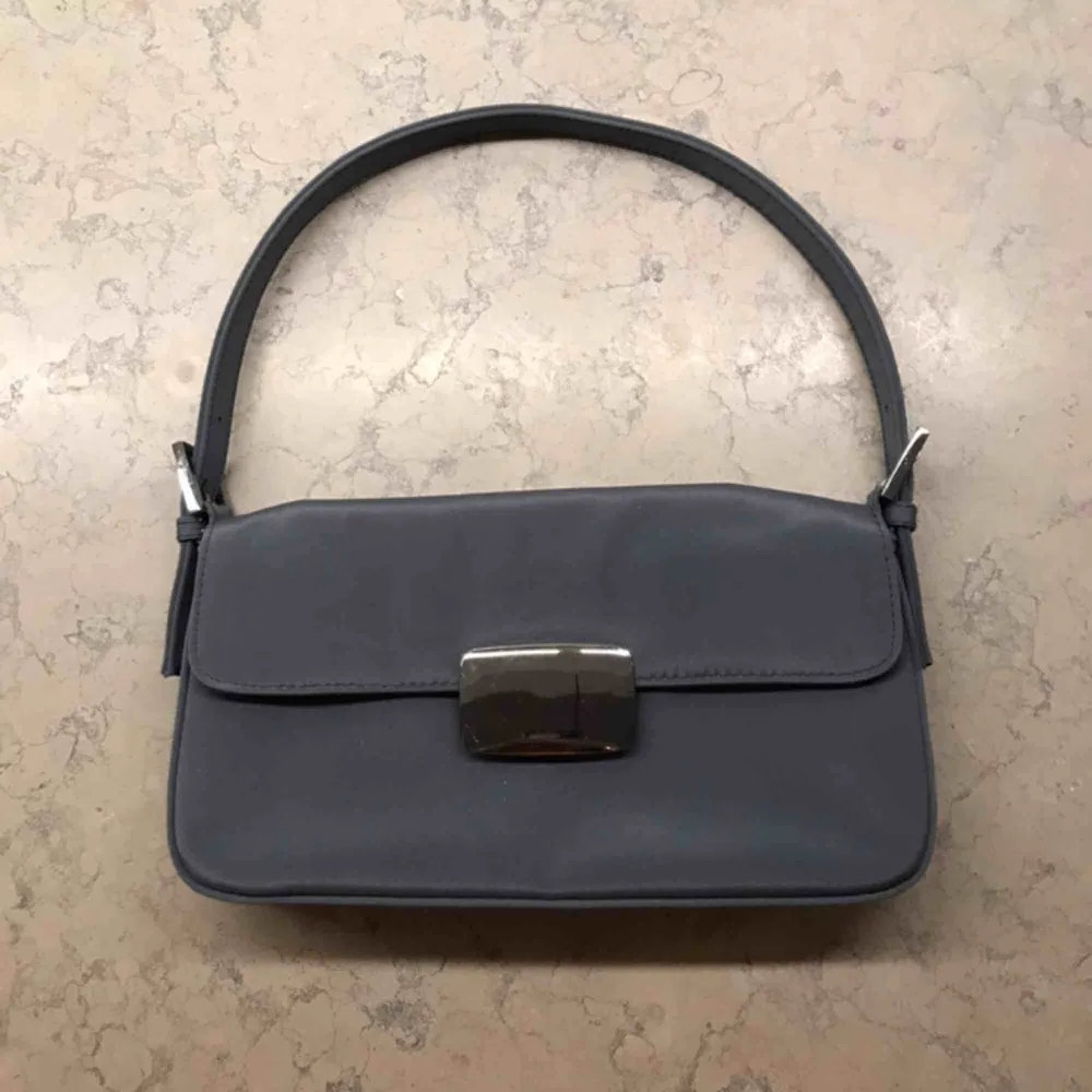 Asfin miniväska/shoulderbag i en gråblå färg, väskan är som ny! Lite repor på spännet men jag ser dem knappt🤪. Väskor.