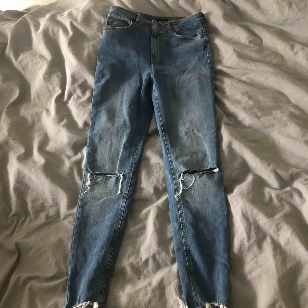 snygga jeans med hål på knäna och snygga slitningar längst ner . Jeans & Byxor.