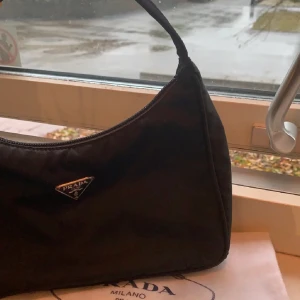 Prada tessuto mini bag - Säljer min jätte fina vintage prada väska då den inte används, 100% äkta, den är köpt på the vintage bar där allt kontrolleras innan den sälj, jätte fin och passar till allt😍✨har tyvärr inget kvitto, men äktehetsbevis finns