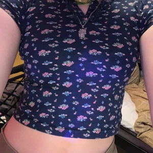 Blommig baby tee🦋 - Säljer denna blommiga baby tee som jag hade nör jag var liten. Tröjan har inga hål eller fläckar.🦋💞 (tröjan passar mig som är en S)