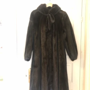 Minkpäls  - Sagamink, i nyskick. Stl. 38-40. Pälsen är endast använd ett fptal ggr och är i perfekt skick. Den gjordes sv körsnär Hans Knutsén som gåva till min mor på hennes 50-årsdag. 