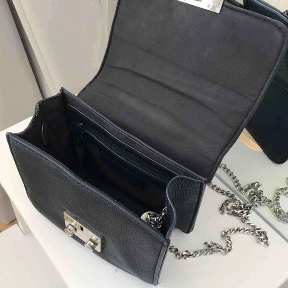 Liten handväska från DonDonna med silverkedja säljes, litet fack innuti med dragkedja. . Väskor.