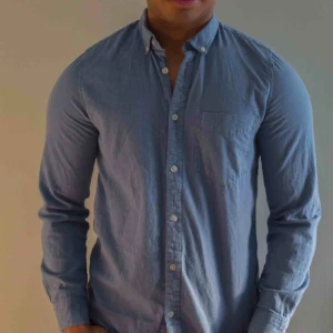  - Ljusblå skjorta från homebound. Plagget är slimfit och i fint skick.