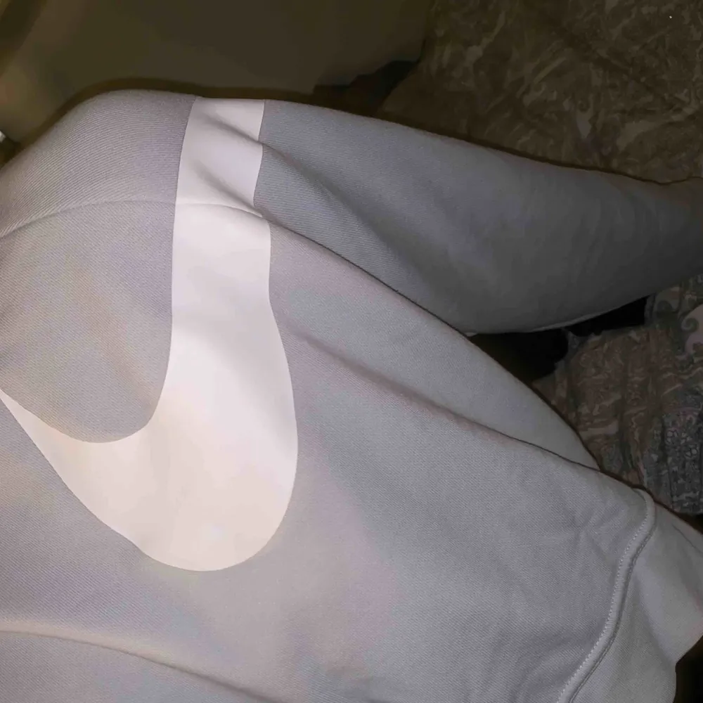 En oversize croppad sweatshirt i en ljusblå färg med ett stor vitt Nike märke på ut mot ena axeln. Super snygg att ha till lite högmidjade byxor. . Tröjor & Koftor.
