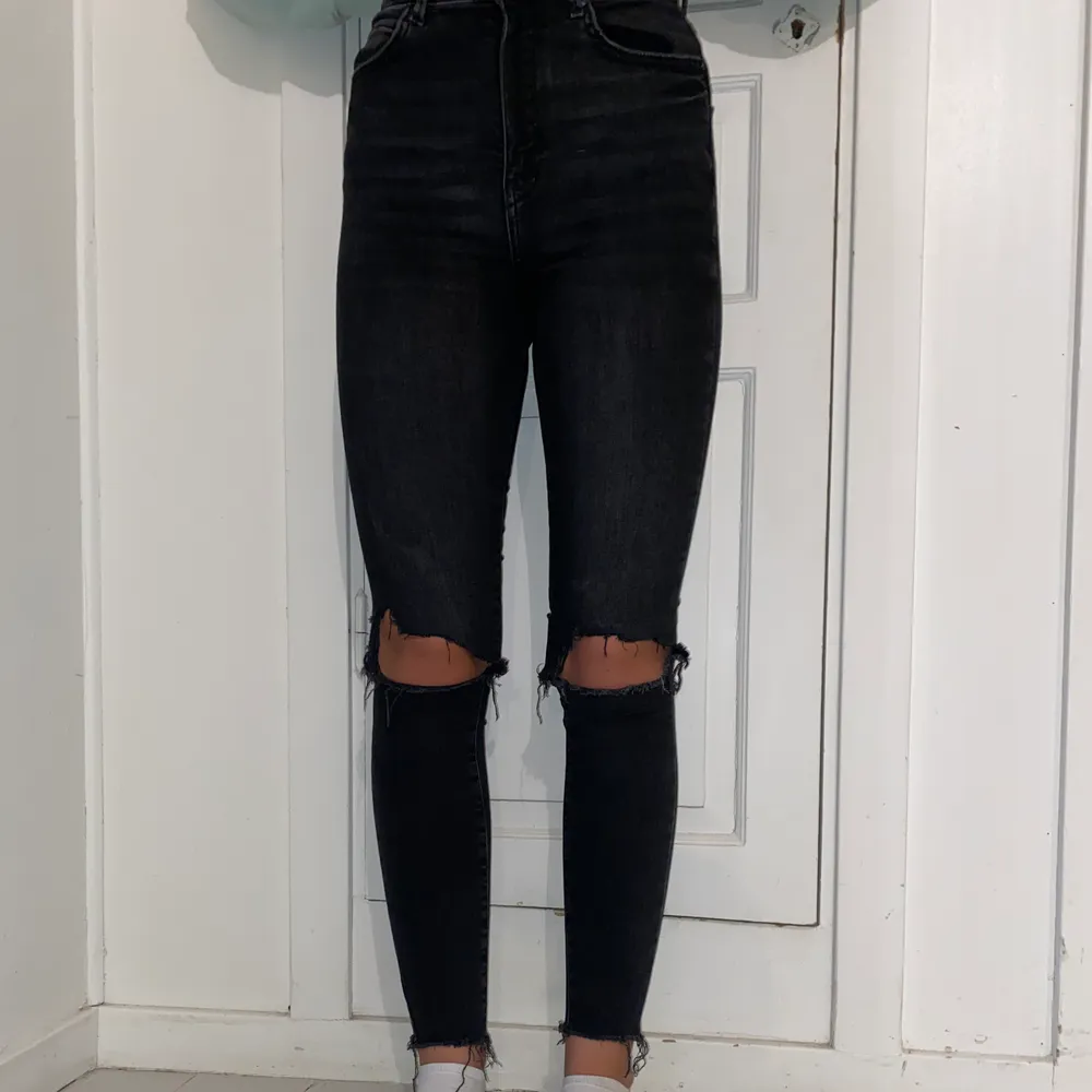 Säljer ett par grå/svarta jeans med hål på knäna från Gina Tricot. Strl 36. Jeans & Byxor.