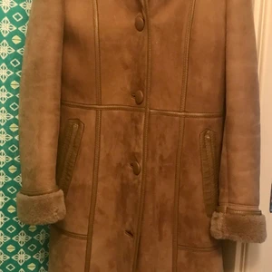 Figursydd pälskappa - Lång, tjock, varm pälskappa i strl 40, mer som 38. Köpt i Linköping, second hand, men tillverkad i Malmö/Örebro. Aldrig använd av mig men räcker ner till knäna på mig som är 174 cm.