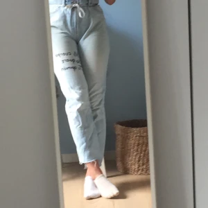 Högmidjade jeans  - Ett par snygga högmidjade jeans från BikBok i storlek M. Texten är ditmålad på spanska och betyder min kropp vill inte ha din åsikt. Säljer för att dem tyvär är för stora. 