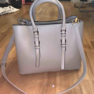  - En beige väska från Åhléns. Helt oanvänd och väldigt fin och rymlig. Köparen står för frakt (95kr) eller mötas upp i Karlstad 