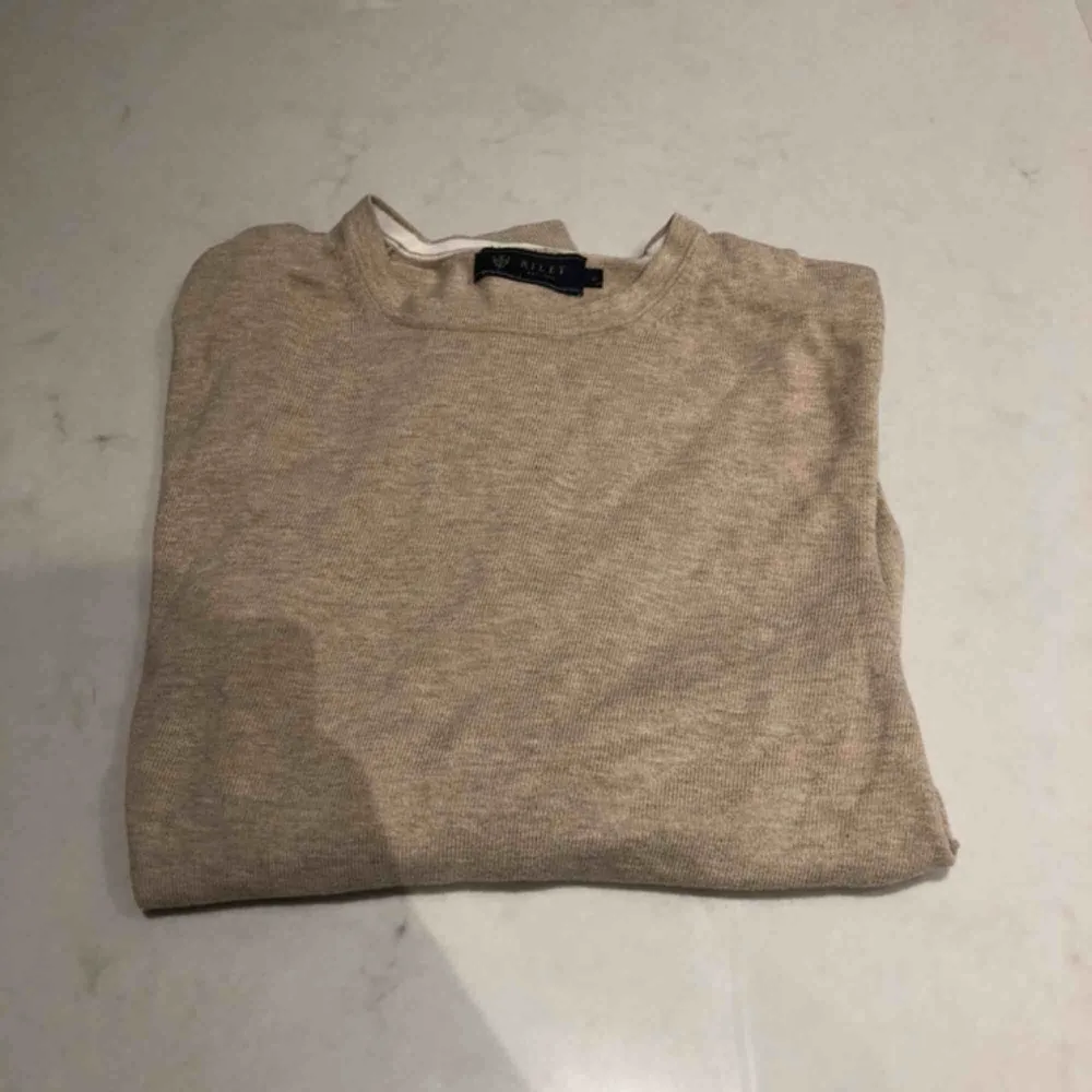 Beige tröja från märket Riley. Köptes från en brothers butik. väldigt snygg med eller utan en skjorta under. Passae Xs,S möjligen m. Kunden står för frakten :). Tröjor & Koftor.