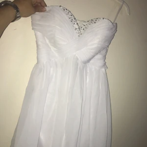  - Använd en gång, vit kortklänning, öppen rygg, med "diamanter/paljetter" vid bysten. Ordinarie pris ca 1500kr