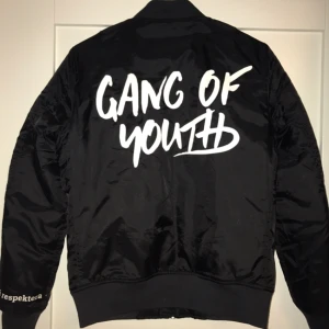  - Bomberjacka med tryck "GANG OF YOUTH" på ryggen och de fina värderingarna "Vi ser. Vi hör. Vi respekterar" runt handleden. Jackan är i M, men passar även perfekt till de som vanligtvis har strl XS-S. Jackan är lite fodrad så passar perfekt till hösten!