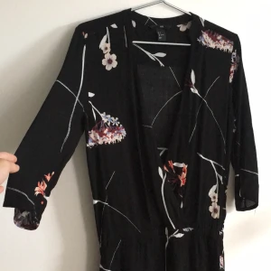  - Kortare klänning med uringning. Vackert blommigt mönster! Nästintill oanvänd. 