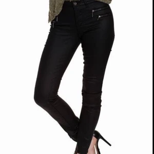  - Glansiga byxor, låga i midjan, svarta. Använda endast tre gånger, säljes på grund av förstora. Precis som nya. Ordinarie pris 399kr