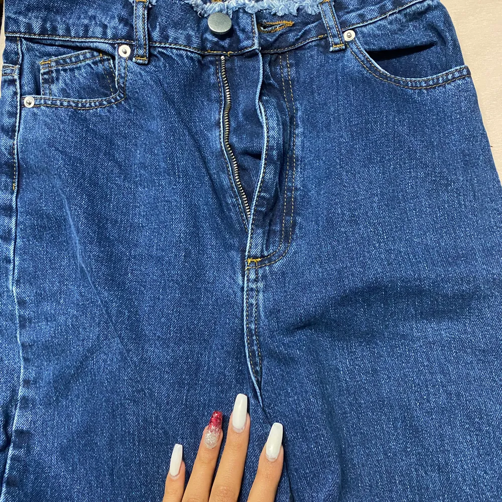 Ett par möekblåa denim jeans som e tajt uppe och lös där nere, lite som momjeans, får en fin form och sitter som ett smäck! Har fina detaljer både vid midjan och vid fötterna . Jeans & Byxor.
