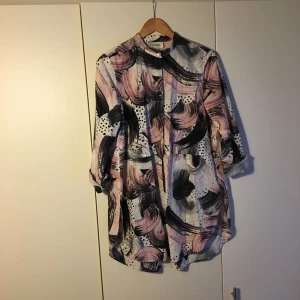  - Collarless Monki shirt with half length hidden button placket and flattering oversize shape. Cotton.