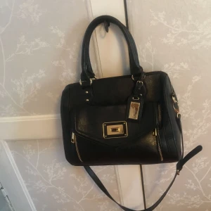  - En fin väska från butiken Aldo. Väskan är svart med guldiga detaljer.