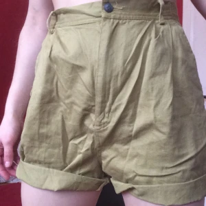  - Khaki green shorts, with very high comfortable waist. 
