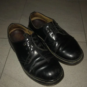  - Låga Dr Martens. Väl använda, tyvärr har det blivit hål där foten böjer sig men de funkar att använda ändå! Utöver det är skinnet fint o shiny. Frakt ingår i priset!