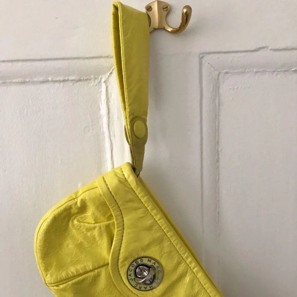 Säljer en gul clutch väska från Marc Jacobs. . Accessoarer.