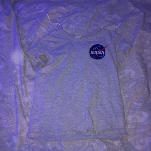 H&M T-shirt Nasa  - En grå T-shirt från H&M men ett litet nasatryck uppe i hörnet. Nästan aldrig använt så skick 9/10. Den kostade runt 99kr när jag köpte den. I strl xs är den. 