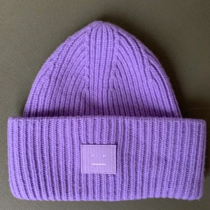 Acne mössa - Lila acne mössa köpt förra hösten💜 Jätte fint skick, ej använd i år och säljer då jag nu har en annan färg och den då inte kommer till användning💟 perfekt nu till vintern⛄️ köparen står för frakt😃 högst bud kan köpa😃 högst bud: 800