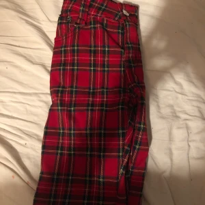 Rödrutiga byxor  - Rödrutiga byxor från banned. Nästan oanvända. Storlek M. Hund och katt finns i hemmet. 