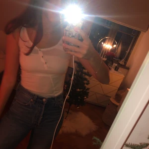 Vitt linne med knappar - Ett gulligt vitt linne med knappar som man kan öppna om man vill! Bra skick😍 Köparen betalar frakt!