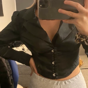 Svart blus i satin material - Helt oanvänd blus då den inte riktigt var min stil, storleken är i S men den är mer mot XS 