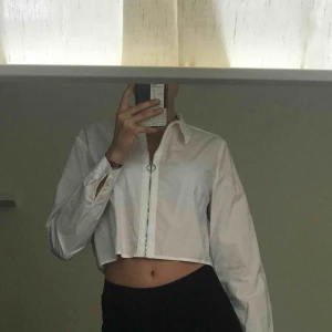  - Vit fin skjorta Liten i storleken. Helt oanvänd  Dragkedja som går hela vägen upp samt ner. Kroppad 