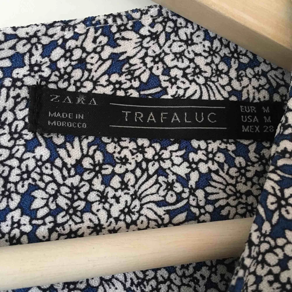 Söt byxdress från Zara, inköpt för flera år sedan men knappt använd. Blå-vitt blommönster och en ficka på var sida av ”byxdelen”.  Dragkedja längs ryggen.. Övrigt.