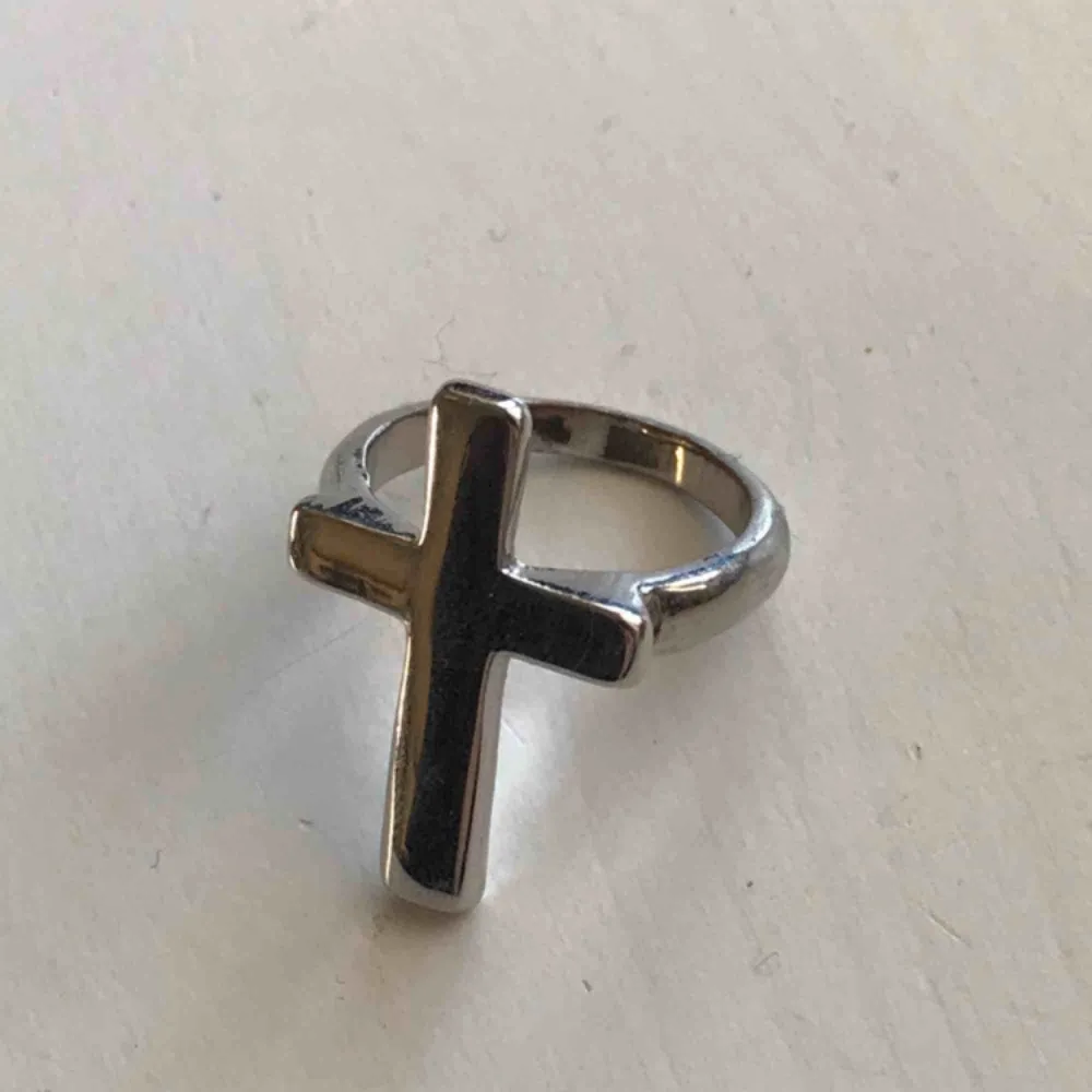 En ring med ett kors. Diametern är 1,8mm. . Accessoarer.
