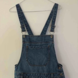  - Blåa hängselbyxor med slitningar. Köpta på Primark i England. Aldrig använda. 