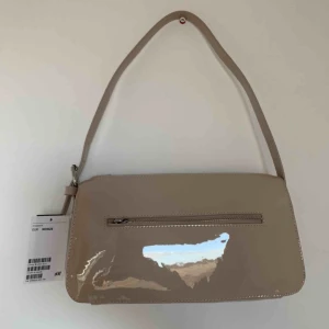  - Helt ny väska från hm! Rymlig i fin beige, lack färg med en ficka på yttersidan. Frakt för 63kr tillkommer 🌼 