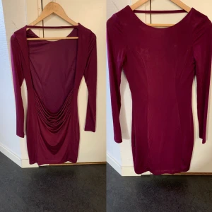 Vinröd cocktail-klänning - En sparsamt använd, vinröd cocktailklänning. Öppen rygg som går långt ner för hela ryggen. Silkesliknande material.