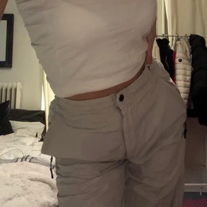 Adidas byxor  - Adidas byxor, beiga med gröna detaljer. Har sytt in midjan så den passar strl XS-S! Raka/utsvängda i benen.