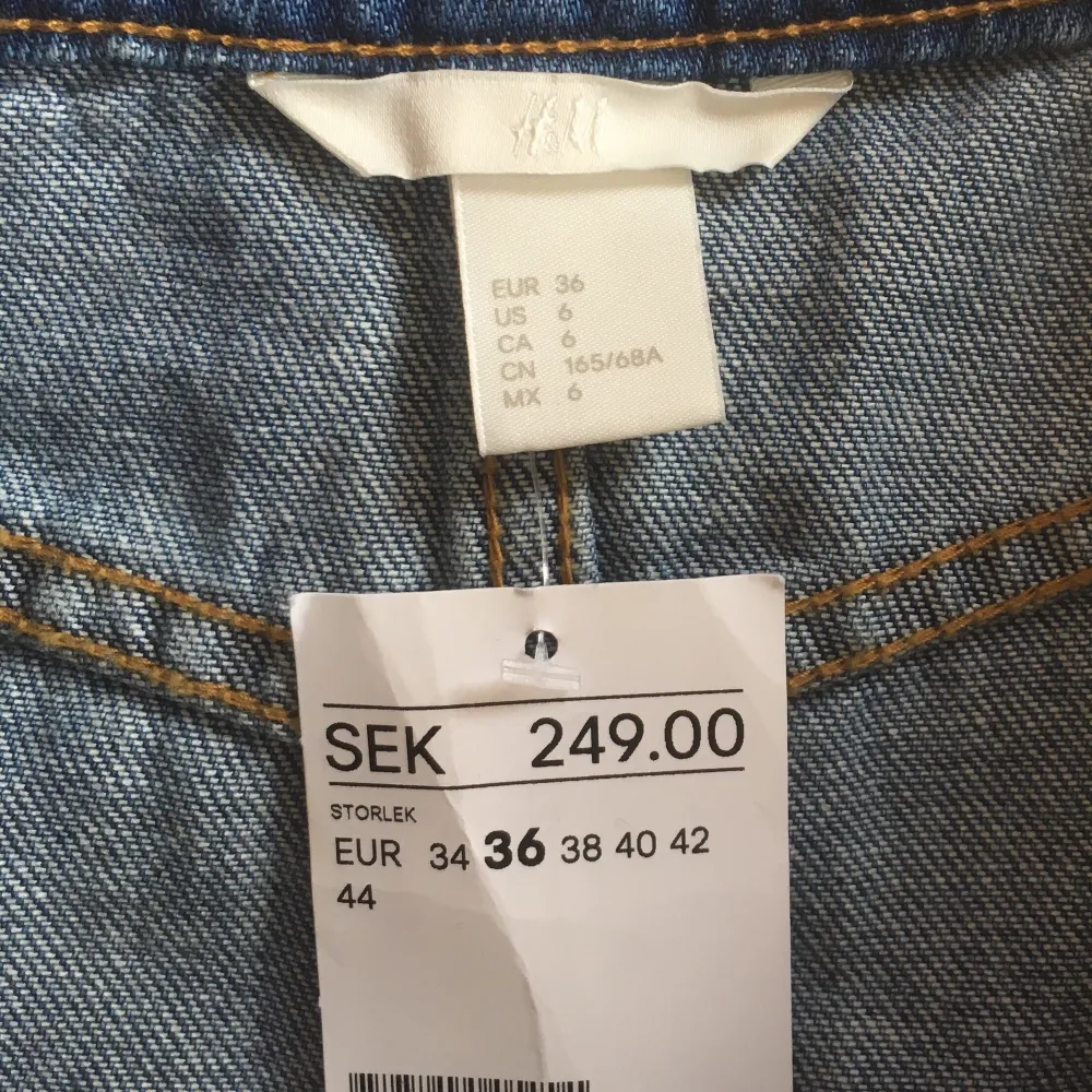 Helt oanvänd jeanskjol från H&M i mellanblått jeanstyg, storlek 36. Når till mitten av låret på mig som är 171 cm. Fickor på framsidan! Somrig och fin☀️🌸🌿Köpt för några år sedan men helt oanvänd pga fel storlek. Prislappen är kvar. Frakt tillkommer, 66 kr. Kjolar.